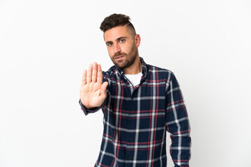 Fototapeta premium Caucasian man isolated on white background making stop gesture
