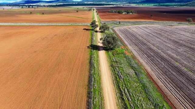 Aerial video following a car travelling along a dirt road through the rural landscape near Gunnedah, NSW, Australia