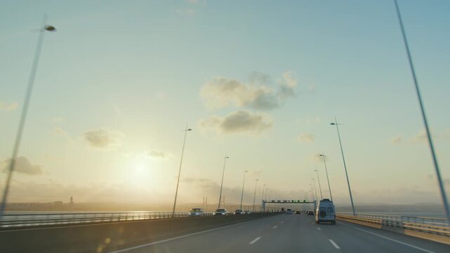 Driving on Vasco da Gama cable stayed bridge at sunset view from car camera, Lisbon, Portugal. Longest bridge in Europe over Tagus river. 