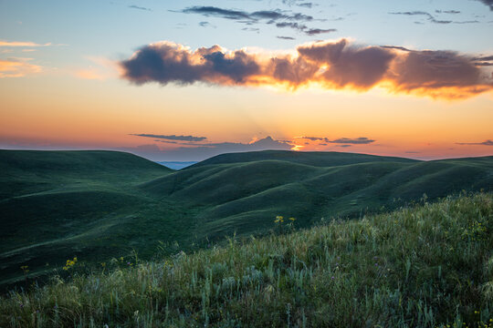 Summer sunset at Hills in the Orenburg region, Russia. Hilly terrain, mountain fields. The beginning of the Ural Mountains. The Dolgiye Mountains.
