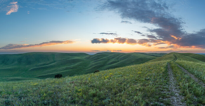 Summer sunset at Hills in the Orenburg region, Russia. Hilly terrain, mountain fields. The beginning of the Ural Mountains. The Dolgiye Mountains.
