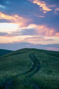 Summer sunset at Hills in the Orenburg region, Russia. Hilly terrain, mountain fields. The beginning of the Ural Mountains. The Dolgiye Mountains.
