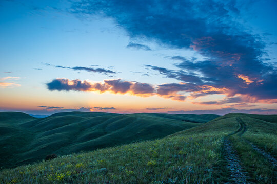Summer sunset at Hills in the Orenburg region, Russia. Hilly terrain, mountain fields. The beginning of the Ural Mountains. The Dolgiye Mountains.
