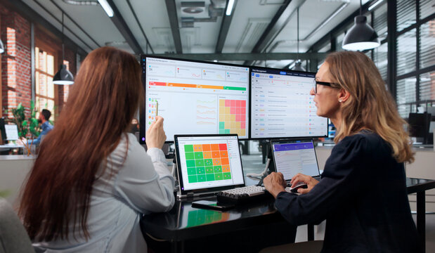 Young Professional Woman Leads Team Meeting Analyzing Software Compliance
