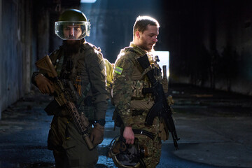 Obraz premium Two Tactical Soldiers Back to Back in Dark Urban Building With Rifles and Combat Gear