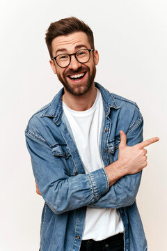 A portrait of a smiling man with glasses, a beard, and a multicolored shirt over a white shirt, set against a solid vivid background.