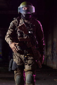Armed Soldier in Tactical Gear With Helmet and Rifle Walking Through Dark Urban Environment