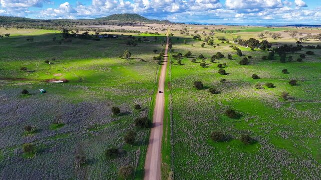 Aerial video following a car travelling along a dirt road through the rural landscape near Gunnedah, NSW, Australia