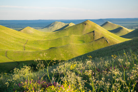 Summer sunny day at Dolgiye Mountains in the Orenburg region, Russia. Hilly terrain, mountain fields. The beginning of the Ural Mountains.