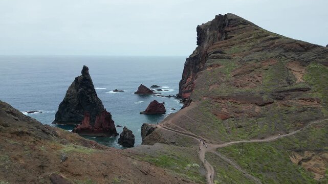 Drone aerial pull back shot of hiking trail and dramatic volcanic cliffs in Madeira