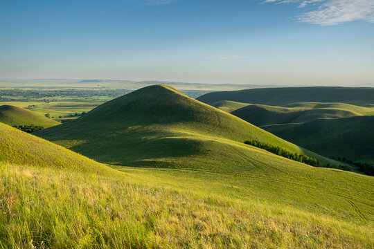 Summer sunny day at Dolgiye Mountains in the Orenburg region, Russia. Hilly terrain, mountain fields. The beginning of the Ural Mountains.