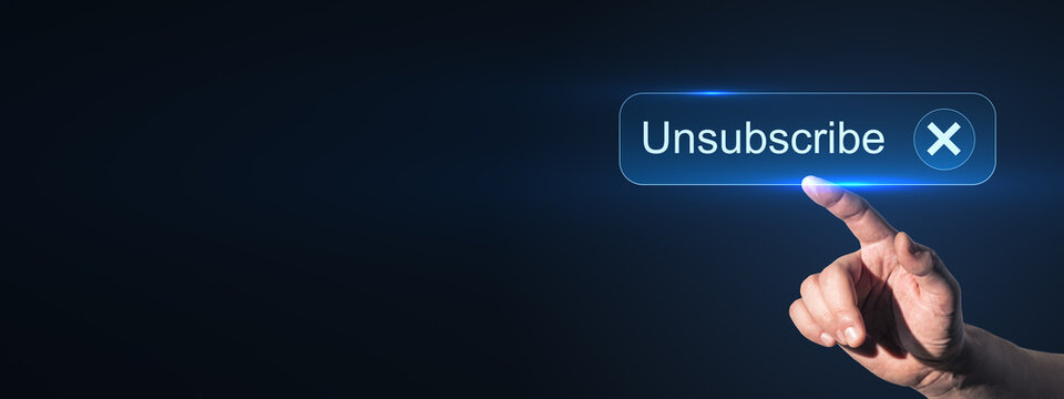 Hand pressing glowing unsubscribe button on dark blue abstract background with copyspace for digital email marketing and communication design.
