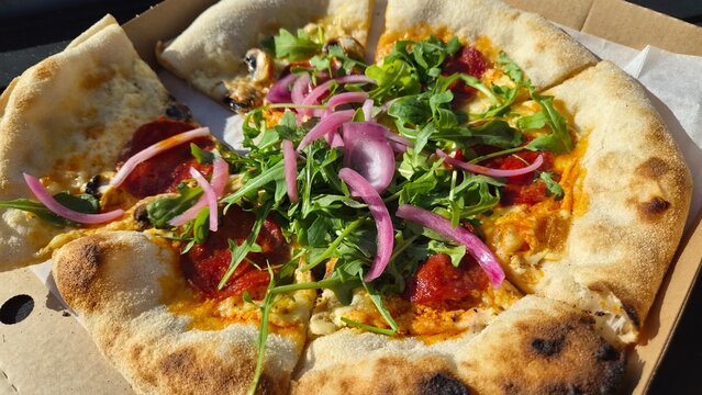 Freshly made pizza with toppings served in a takeout box