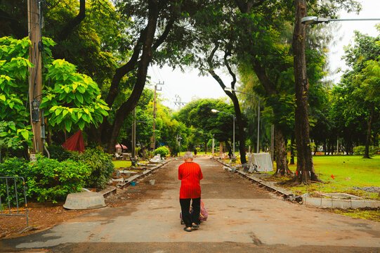 Walking down a quiet path in a green park in Bangkok, Thailand