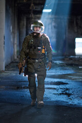 Fototapeta premium Armed Tactical Soldier in Military Gear Walking Through Abandoned Urban Building With Helmet Visor