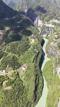 Stunning portrait view of a peaceful river flowing past green hillsides and small settlements on the outskirts of Hefei, Anhui &ndash; 2026