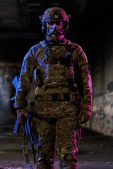Fototapeta premium Armed Soldier in Tactical Gear Standing in Urban Night Environment With Rifle and Helmet