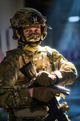 Fototapeta premium Tactical Soldier in Camouflage Uniform Holding Rifle With Helmet and Night Vision Gear in Urban Operation