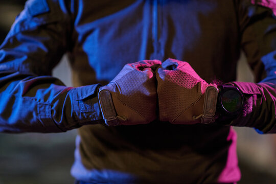 Tactical Gloves With Smartwatch On Wrists Clenched Fists Under Neon Urban Night Lighting