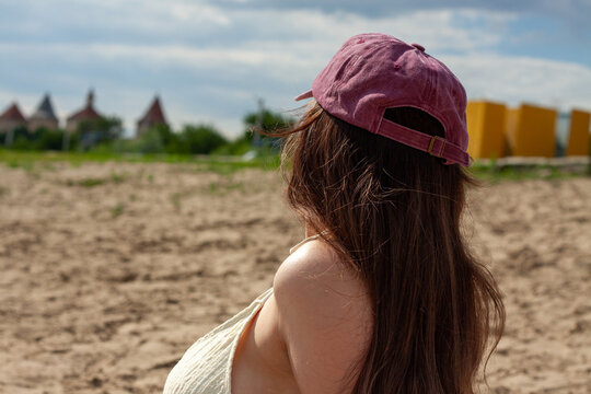 Woman Wearing Cap Looking at View on Sandy Beach