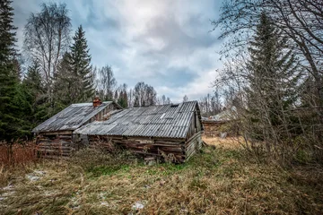 Abandoned and dilapidated old wooden log houses in a remote forest village of Karelia, Russia © es0lex