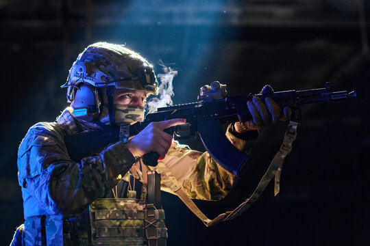 Armed Soldier in Camouflage Military Gear Aiming Rifle in Tactical Night Operation With Smoke