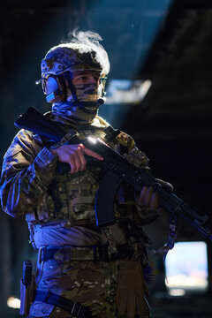 Camouflaged Soldier In Tactical Gear Holding Assault Rifle During Night Operation With Dramatic Light