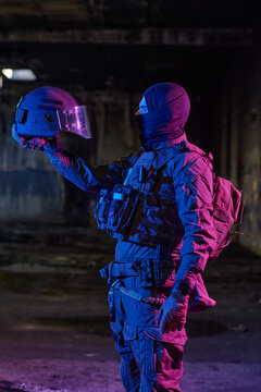 Tactical Soldier In Balaclava Holding Riot Helmet In Dark Urban Military Scene With Neon Lighting