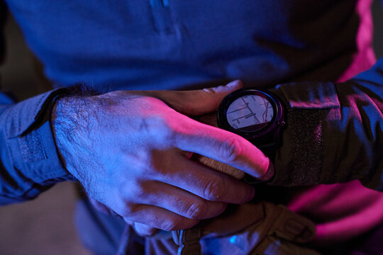 Person Checking Smartwatch Navigation Map on Wrist in Neon Blue and Pink Low Light
