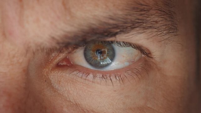 Close up of angry male eye with aggressive tense expression and furrowed brow. Human eye showing anger hostility and emotional stress representing conflict threat and negative emotion concept.