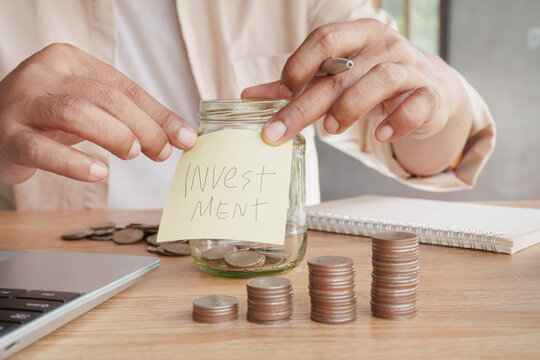 Close-up of hands organizing investment savings, growing coin stacks, glass jar and handwritten investment note, personal finance, wealth management, financial planning, long-term investment growth