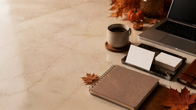 Autumn flat lay with laptop, notebook, coffee, and blank cards on marble surface