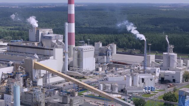 Aerial view of modern pulp and paper mill plant with industrial machinery and wood chips for manufacturing and supply chain