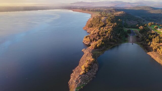 Aerial video flying over Lake Keepit Dam and the surrounding landscape in NSW, Australia. The expansive reservoir, dam wall and rolling countryside