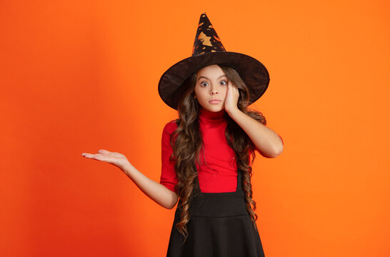 October 31. Teen girl in witch costume. Happy Halloween. Girl witch in Halloween costume isolated on orange. Trick or treat. Celebrate All Hallows party holiday. All Hallows. Presenting copy space