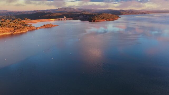 Aerial video flying over Lake Keepit Dam and the surrounding landscape in NSW, Australia. The expansive reservoir, dam wall and rolling countryside