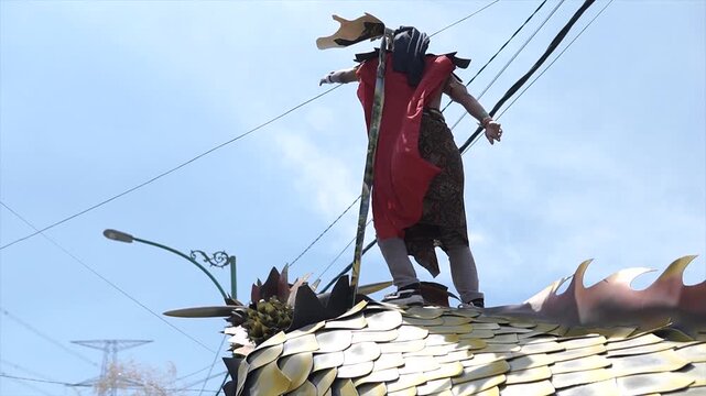 Low angle shot of a performer in traditional Javanese costume on a parade float in 4K resolution.