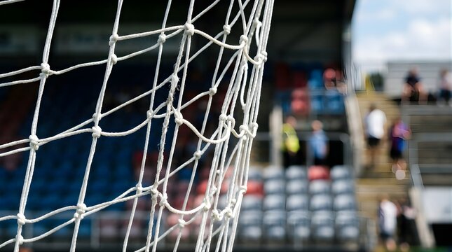 White soccer goal net at a stadium with blurred spectators in background