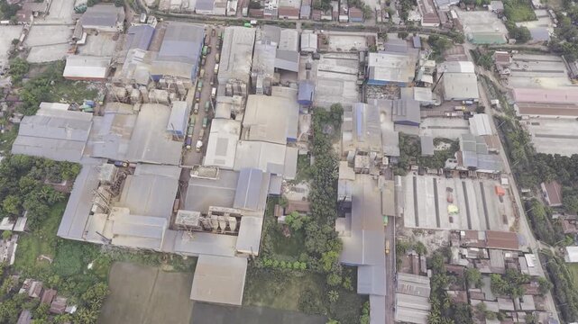 Drone footage moving straight forward above an industrial area in Khajanagar, Kushtia, with factories, infrastructure, rooftops, and the nearby rural-industrial environment.