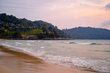 Fototapeta premium Tranquil Beachside Landscape During Sunset With Glistening Waves and Serene Hills