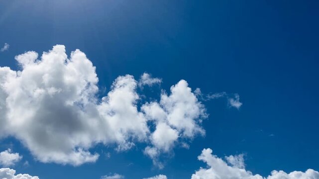 Blue sky, cumulonimbus clouds, and sunlight