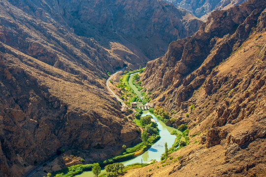 A panoramic view of the Euphrates River winding through a dramatic rocky canyon near Divrigi, Sivas, Turkey. The historic railway line of the famous Eastern Express follows the river through one of An