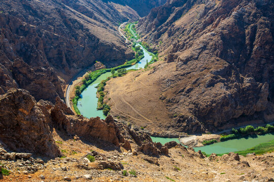 A panoramic view of the Euphrates River winding through a dramatic rocky canyon near Divrigi, Sivas, Turkey. The historic railway line of the famous Eastern Express follows the river through one of An