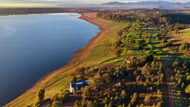 Aerial video flying over Lake Keepit Dam and the surrounding landscape in NSW, Australia. The expansive reservoir, dam wall and rolling countryside