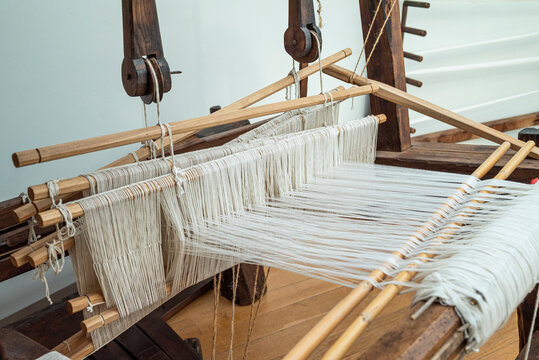 Traditional wooden loom with white threads The Concept of ancient craftsmanship