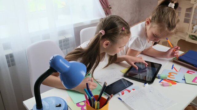 Focused Children Working Together on Digital Tablet to Complete Homework Assignment