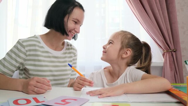 Calm child studying at home with supportive mother peaceful learning