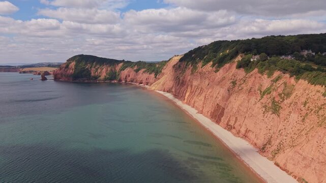 Aerial drone footage of the striking red sandstone cliffs at Jacob's Ladder Beach in Sidmouth, East Devon, England. The video captures the Jurassic Coast, dramatic coastal scenery, and the English Cha