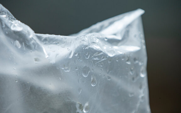 Close up of transparent plastic bag texture with fresh water drops.Close-up abstract shot of a crumpled clear plastic bag covered in fresh water droplets and condensation.