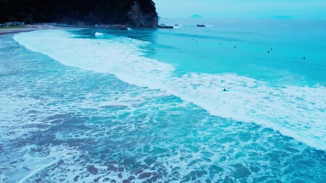 白波が綺麗で波にのるサーファーを早朝に空撮 4K